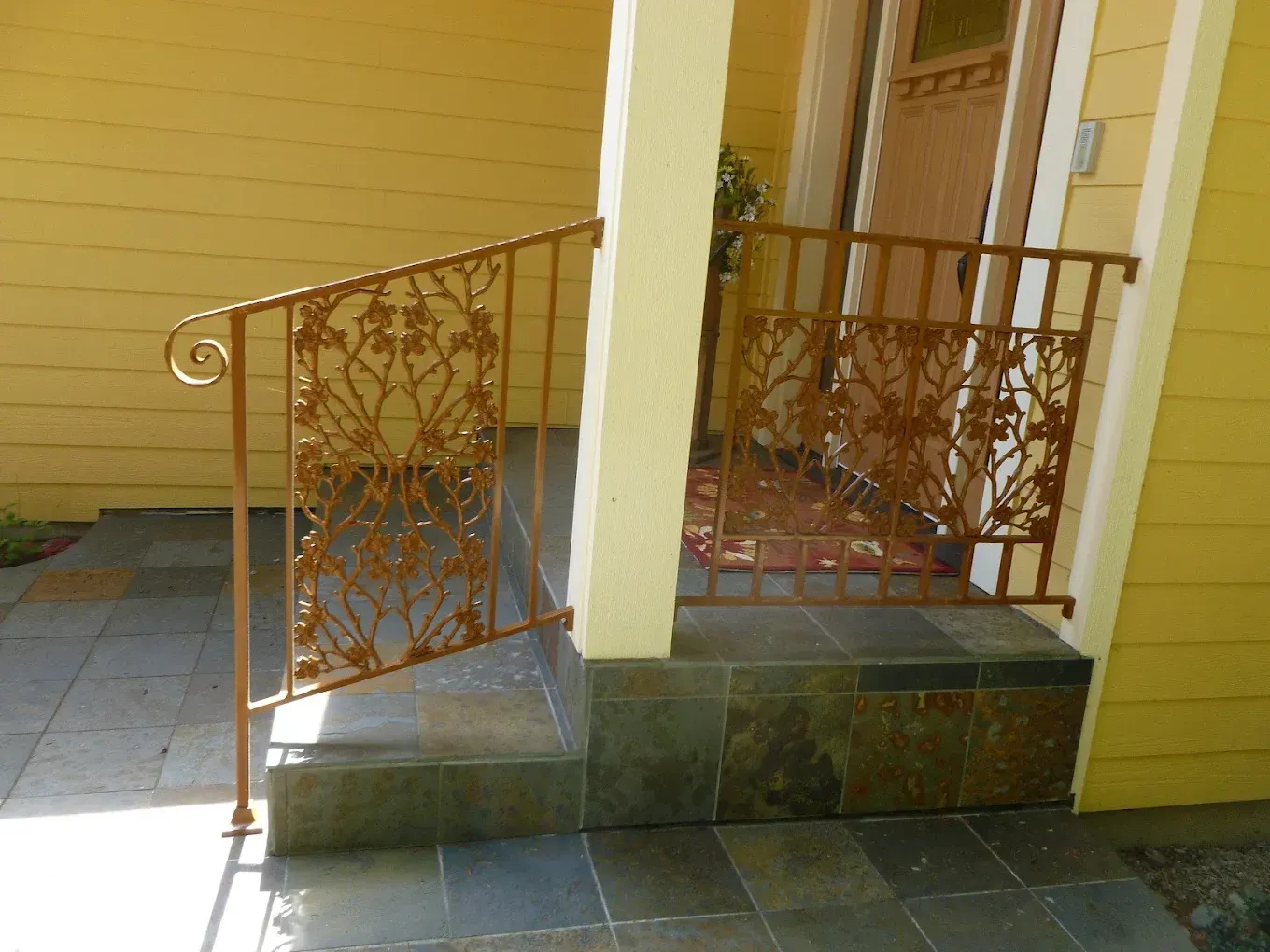 Decorative metal porch railing with custom cut design panels