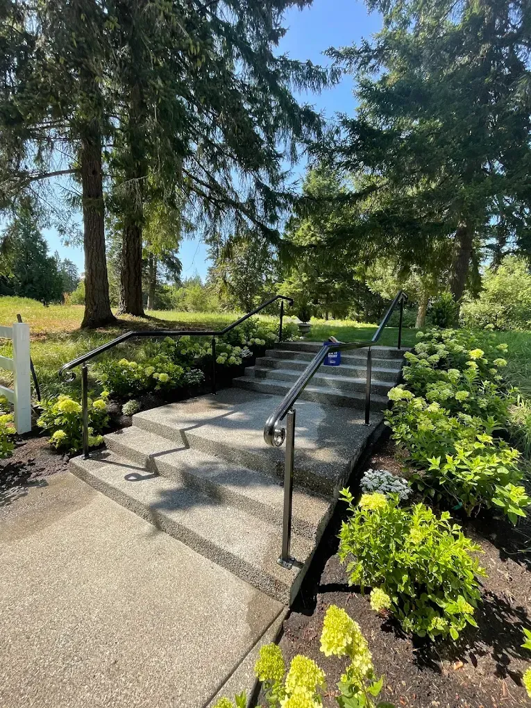 Outdoor pathway stairs with custom welded steel handrails in landscaped setting