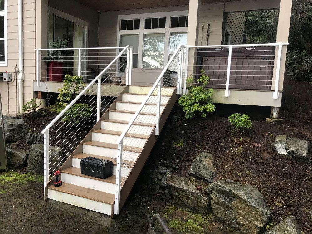 Residential deck stairs with custom welded steel cable railing system