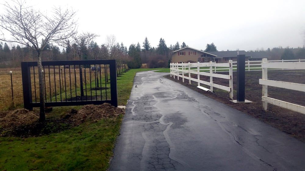 Residential driveway with custom welded steel gate installation