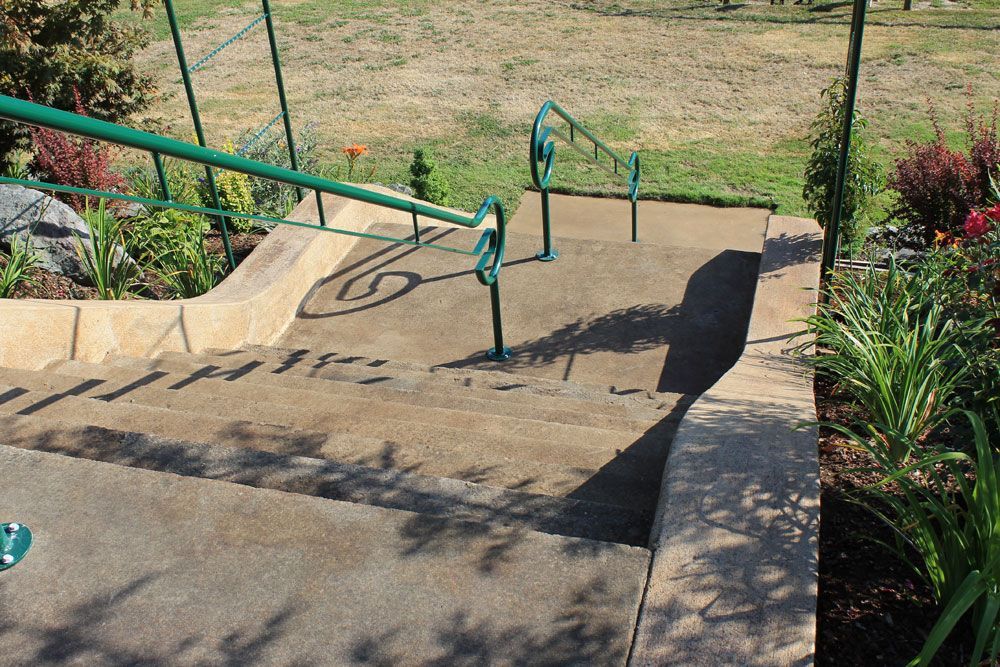Outdoor concrete stairway with custom welded steel ADA handrail system