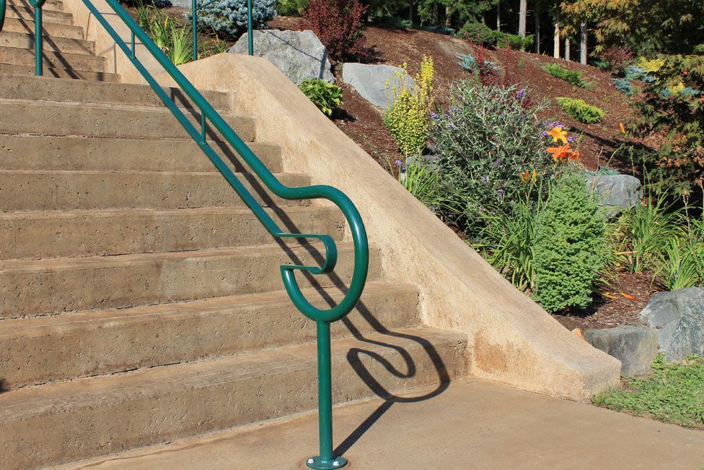 Concrete stairs with custom welded steel ADA handrail in green finish