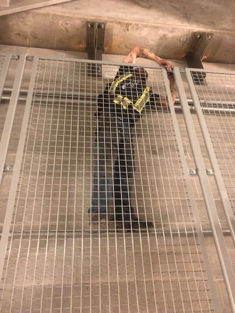 Worker installing or repairing metal security gate panel