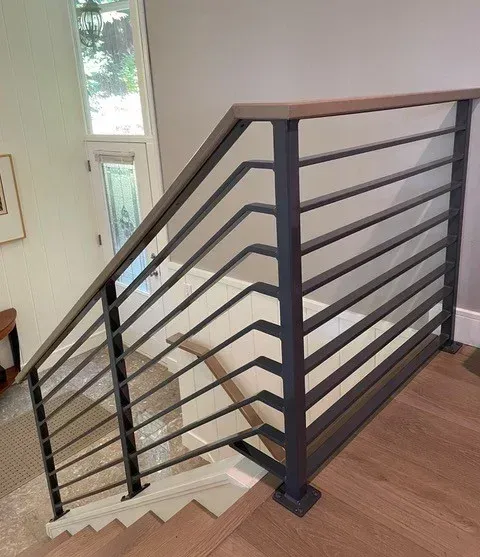 Interior staircase with custom welded steel horizontal railing system