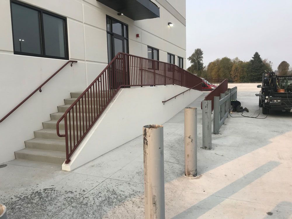 Commercial building exterior stairs with custom welded steel railing system