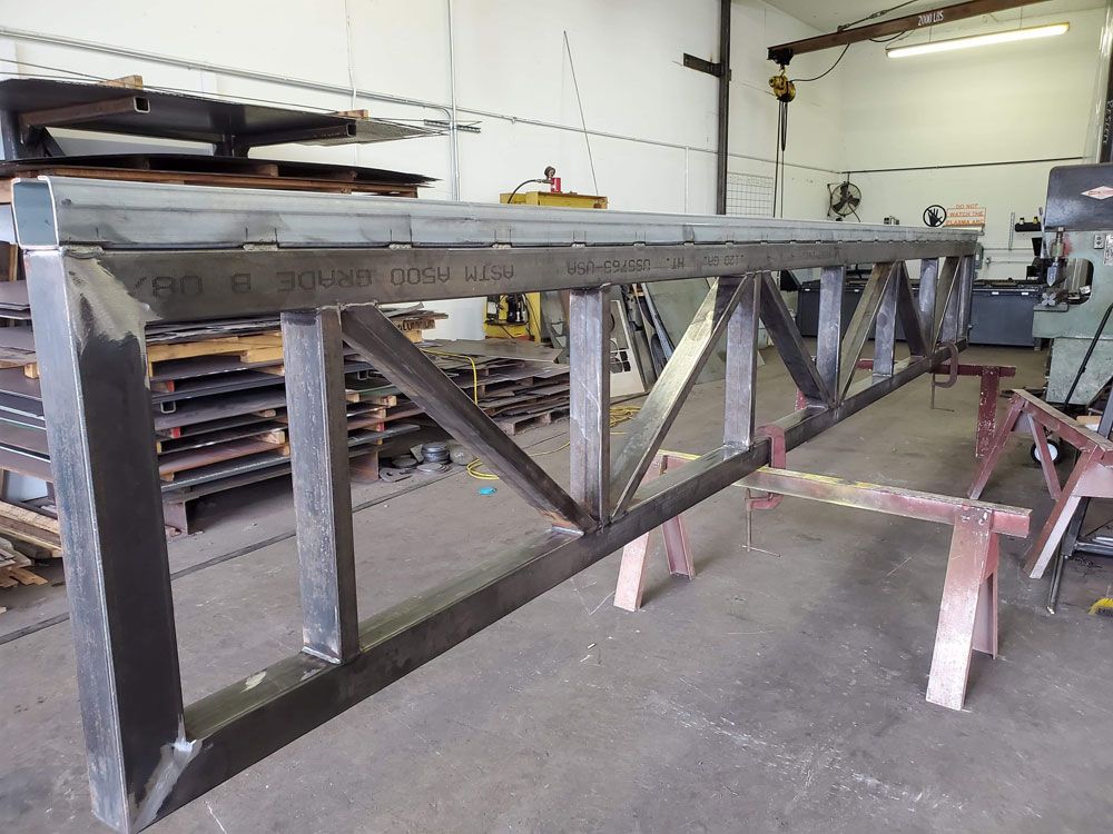 Custom fabricated steel truss structure with welded connections
