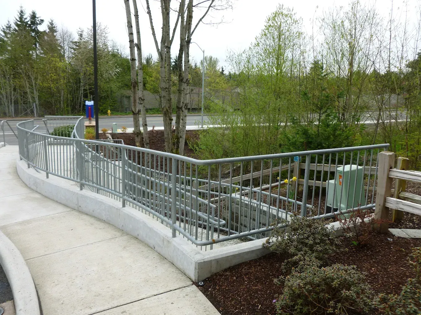 Curved concrete walkway with custom welded steel railing system