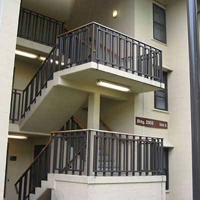 Multi-level apartment stairwell with custom welded steel railing system