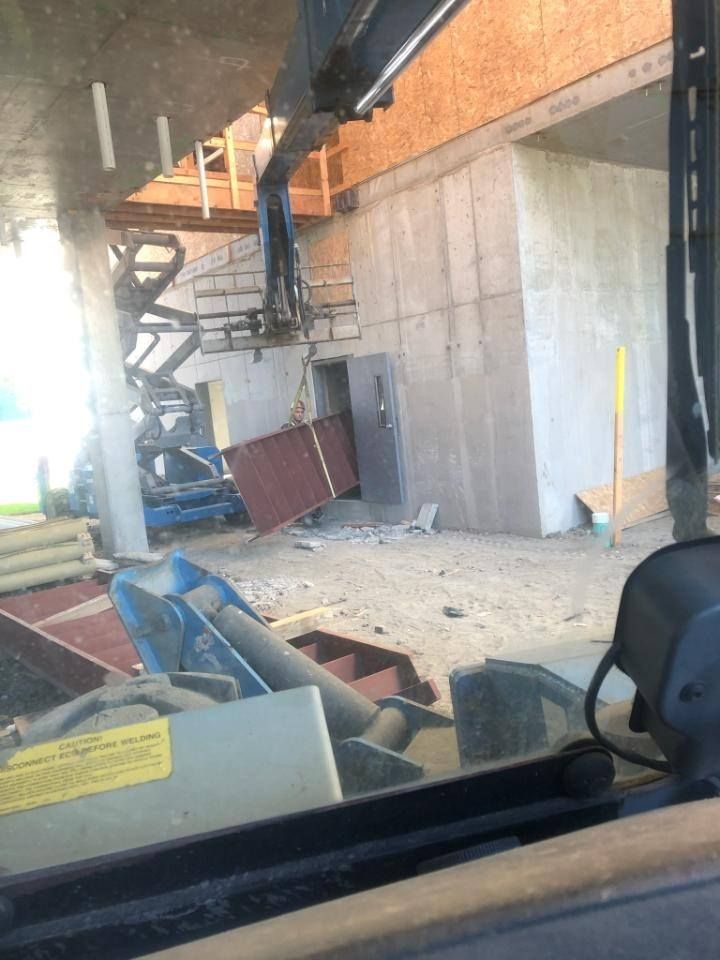 Structural steel stair assembly being installed in confined interior space