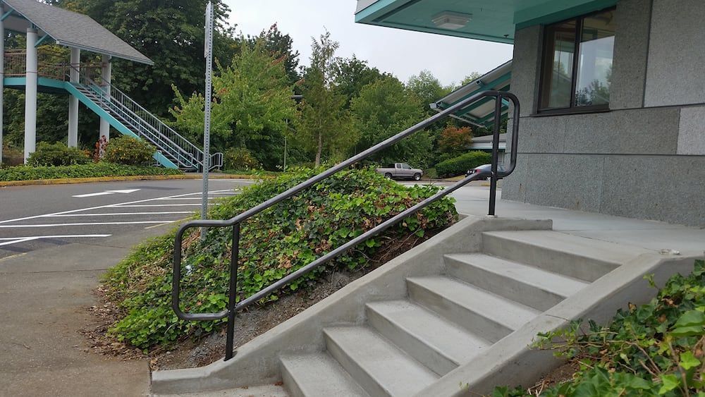 Concrete stairs with custom welded steel handrail installation