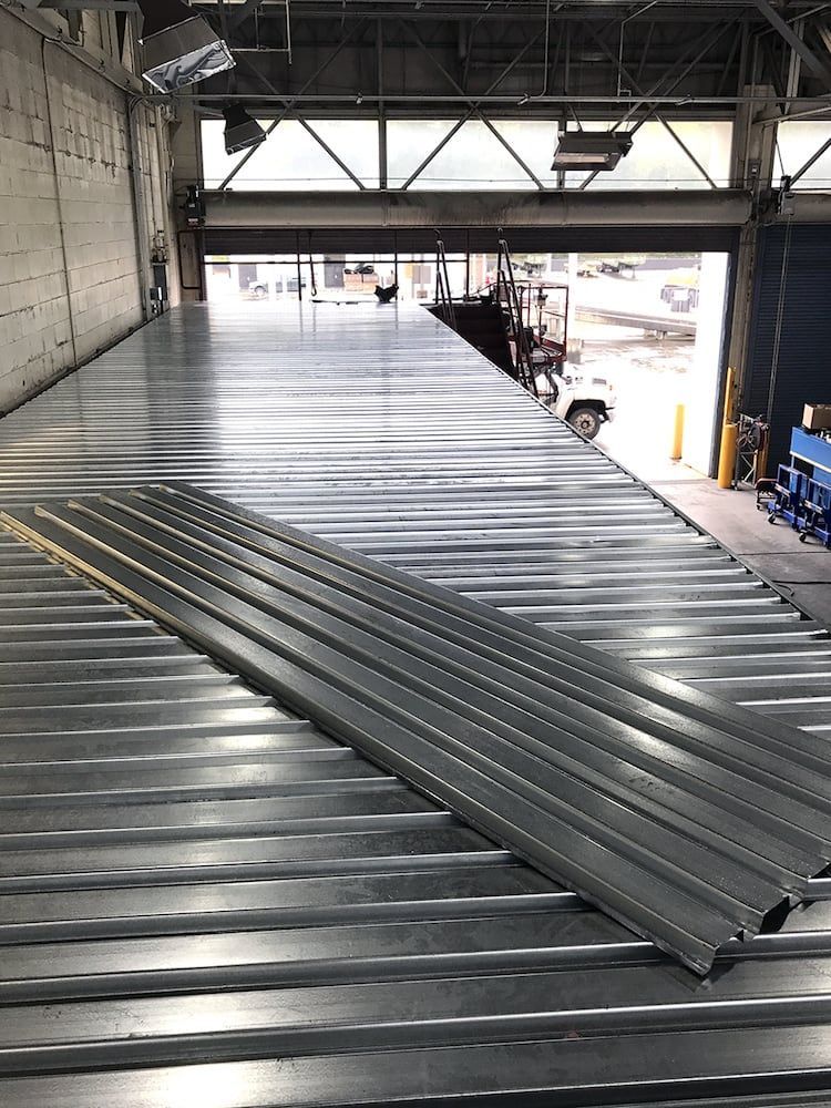 Stacked steel decking or roofing panels in fabrication shop