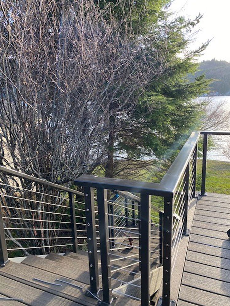 Outdoor deck walkway with custom welded steel cable railing system