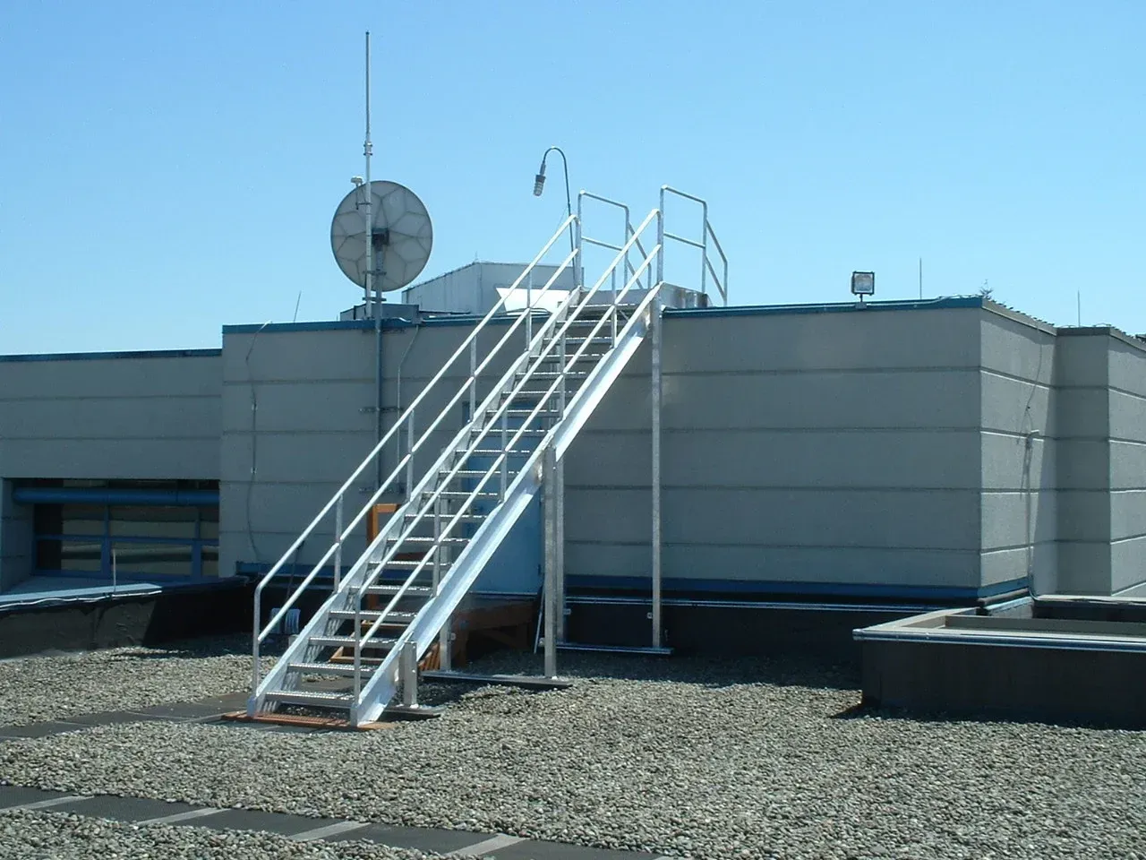 Industrial rooftop access stairs with custom welded steel railing system