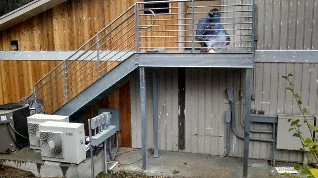 Outdoor stairwell leading to walkway with custom welded steel railing system