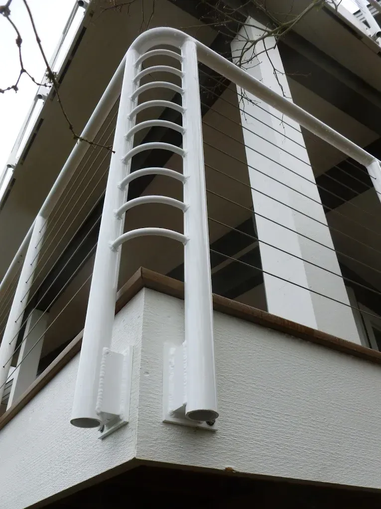 Corner detail of custom welded steel railing system with vertical elements