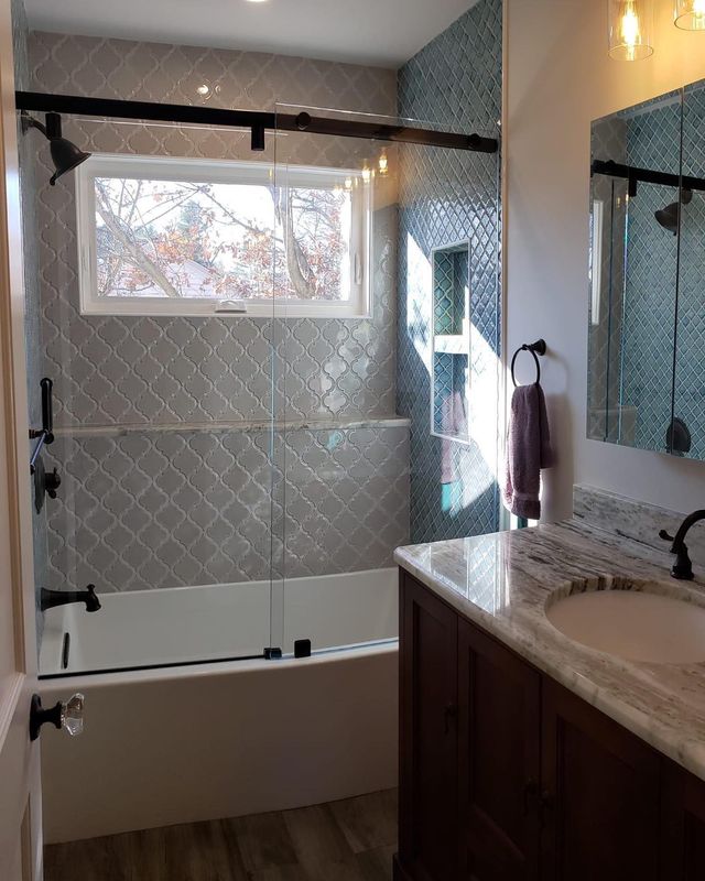 Black framed glass shower door with decorative tile bathroom remodel