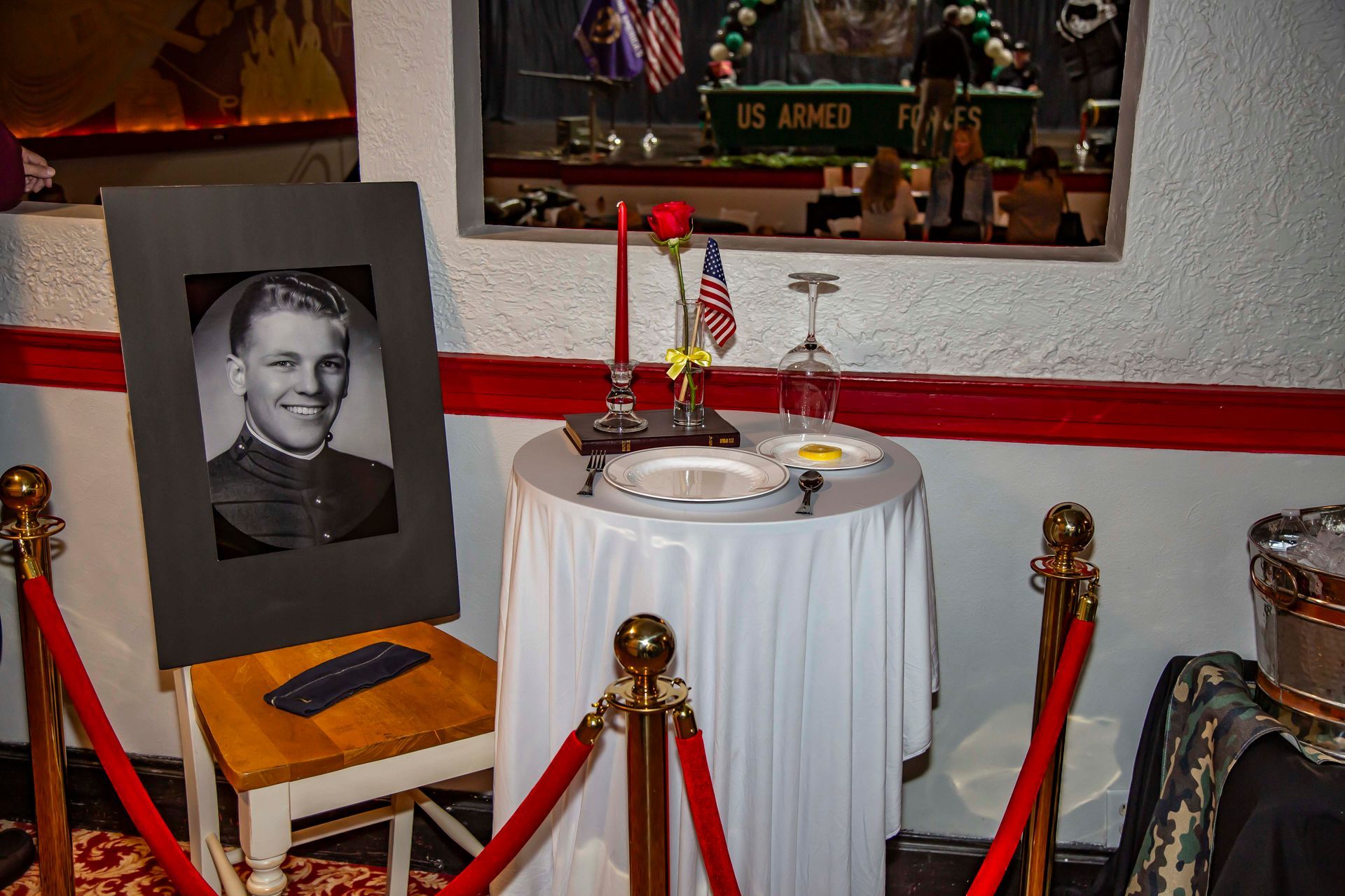 Memorial table with photo, candle, and American flag; a tribute.