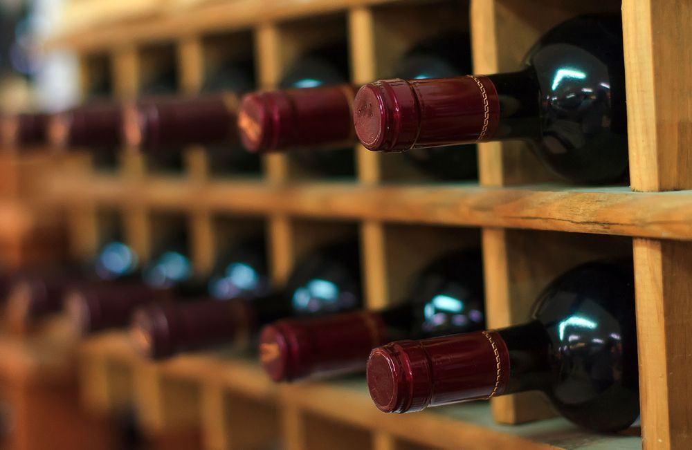 Wine Bottles in a Wooden Rack, Resting on Their Side — BYO Cellars in Stockton, NSW