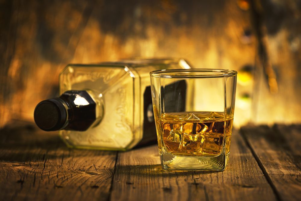 Whiskey Bottle and Glass on Wooden Table — BYO Cellars in Wyong, NSW