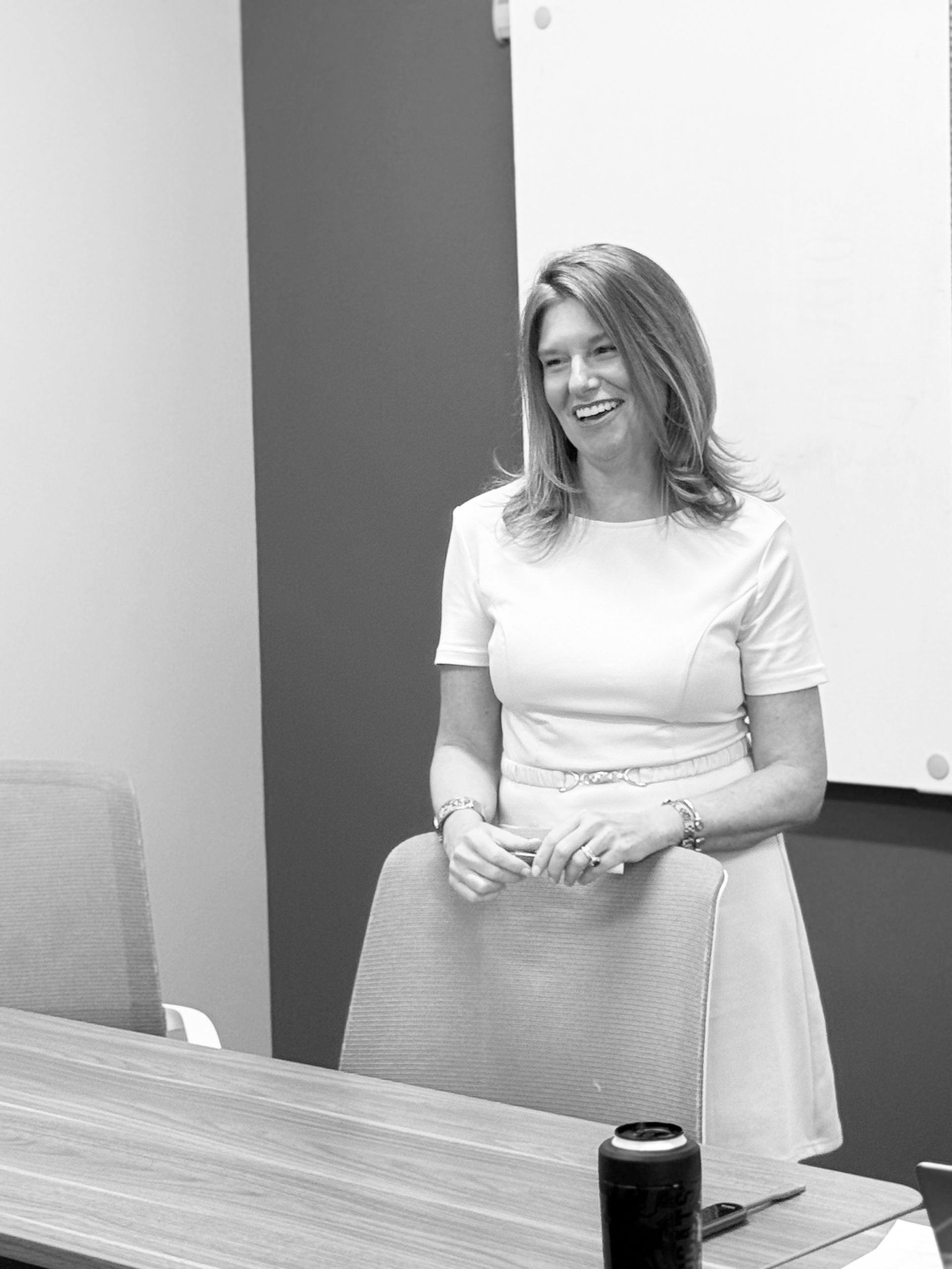 Woman smiling beside a conference chair in a meeting room