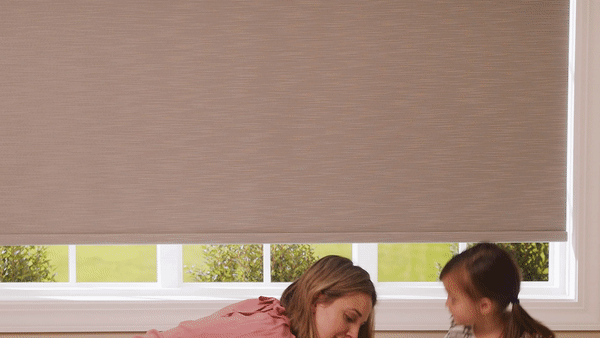 A woman and a little girl are sitting in front of a window.