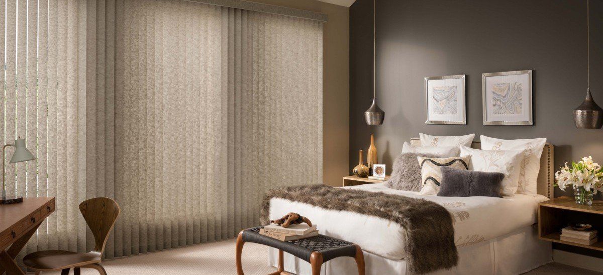 A bedroom with a bed , desk , and blinds on the windows.