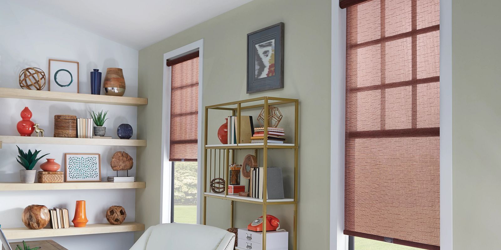 A living room with a couch , shelves , and two windows.