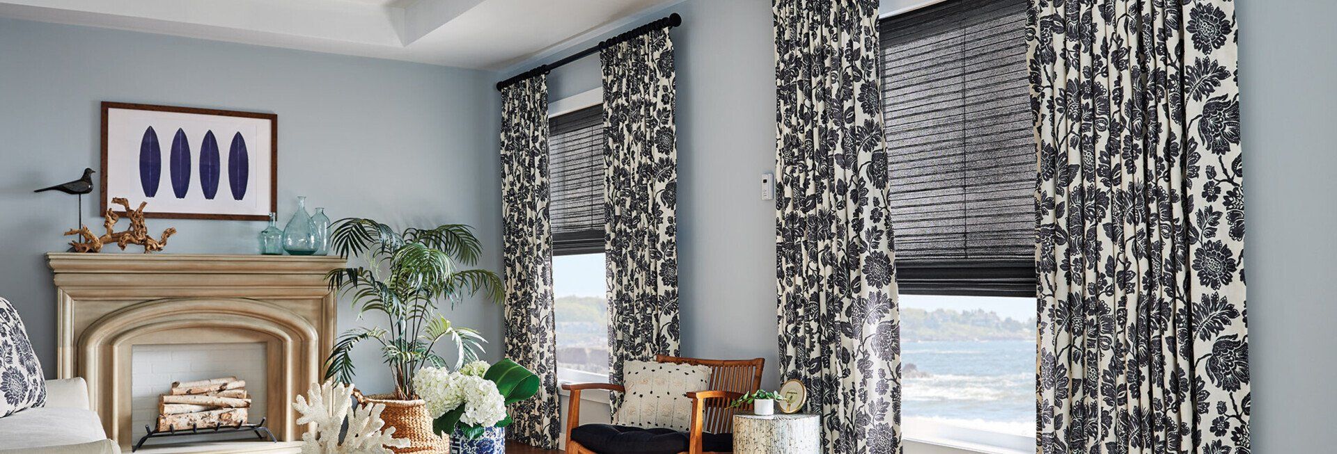 A living room with a fireplace and black and white curtains.