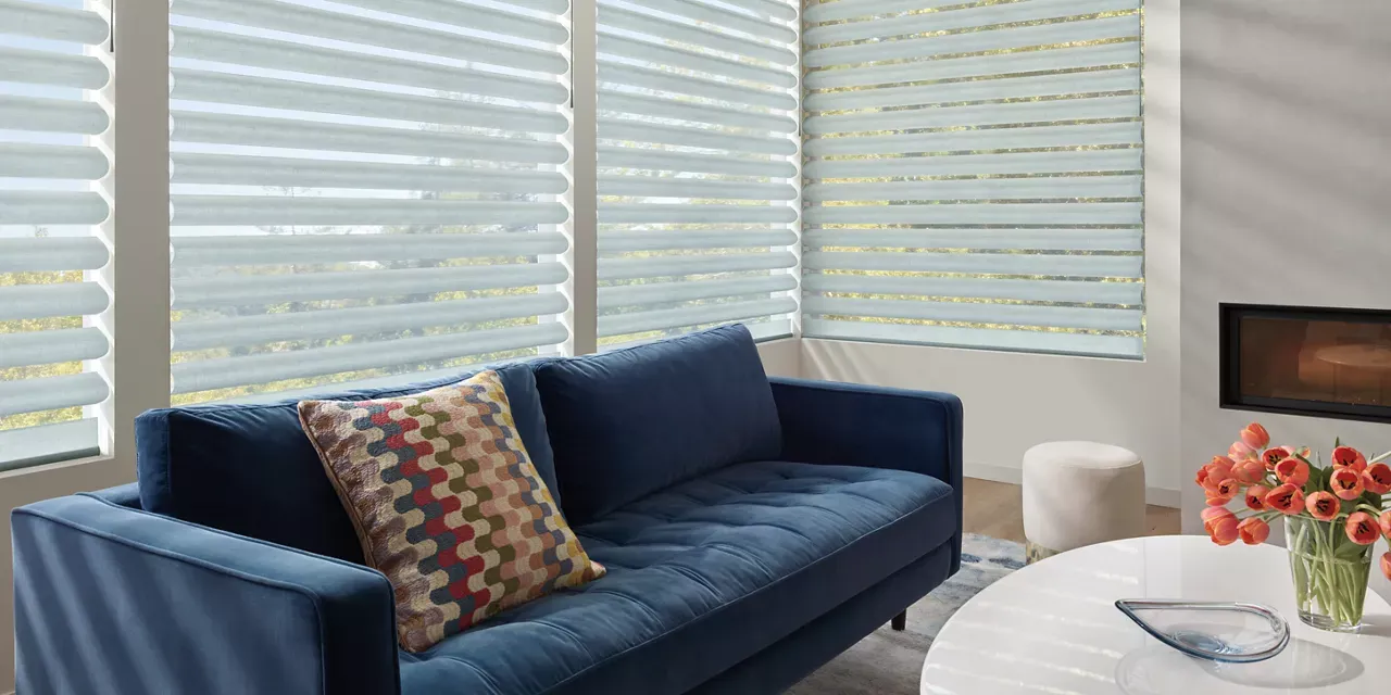 A living room with a blue couch and a white table.