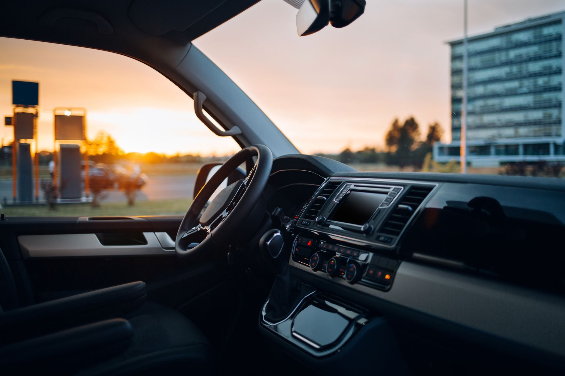 The inside of a car with a sunset in the background.