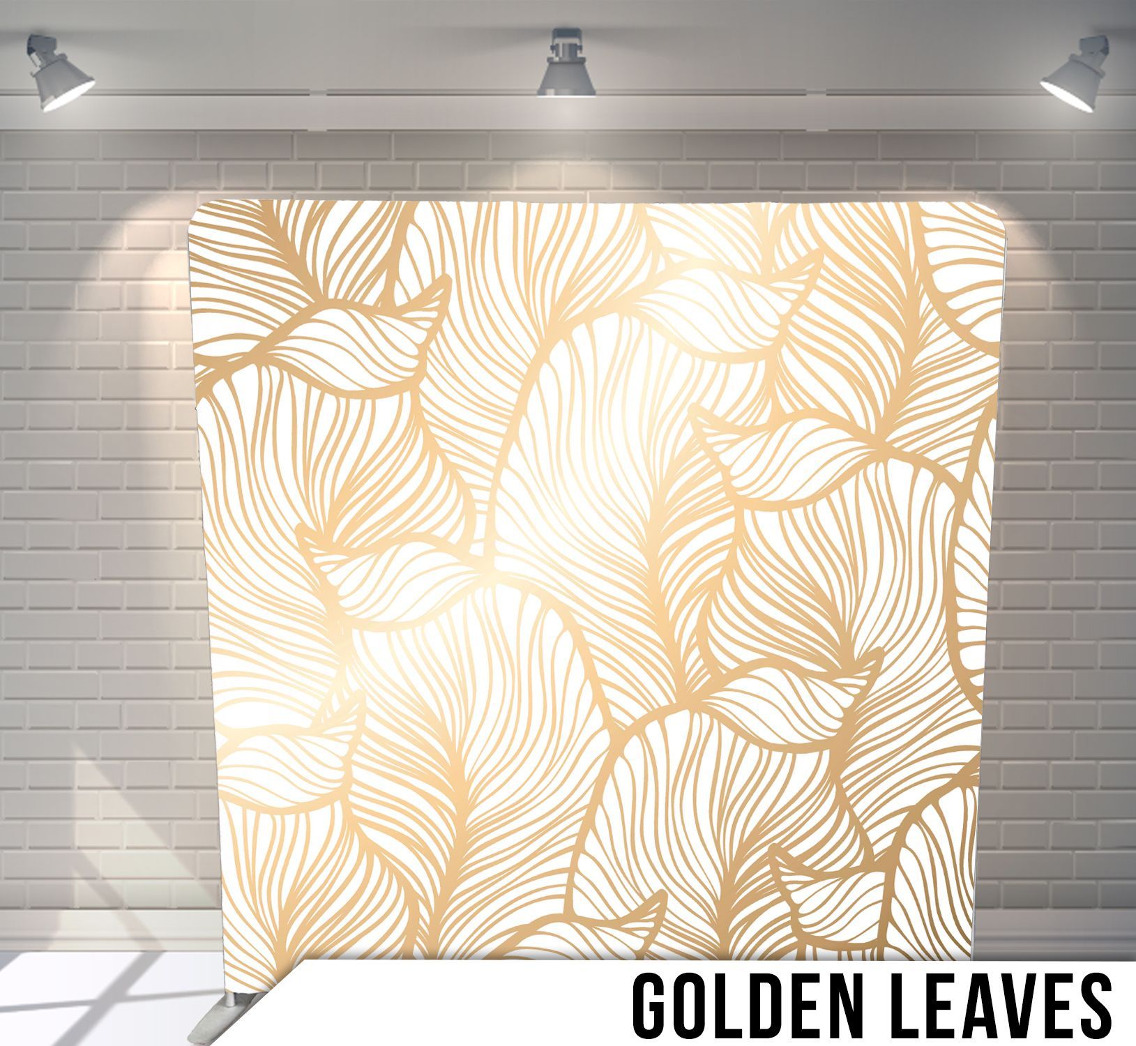 White backdrop with gold leaf design, lit by spotlights.