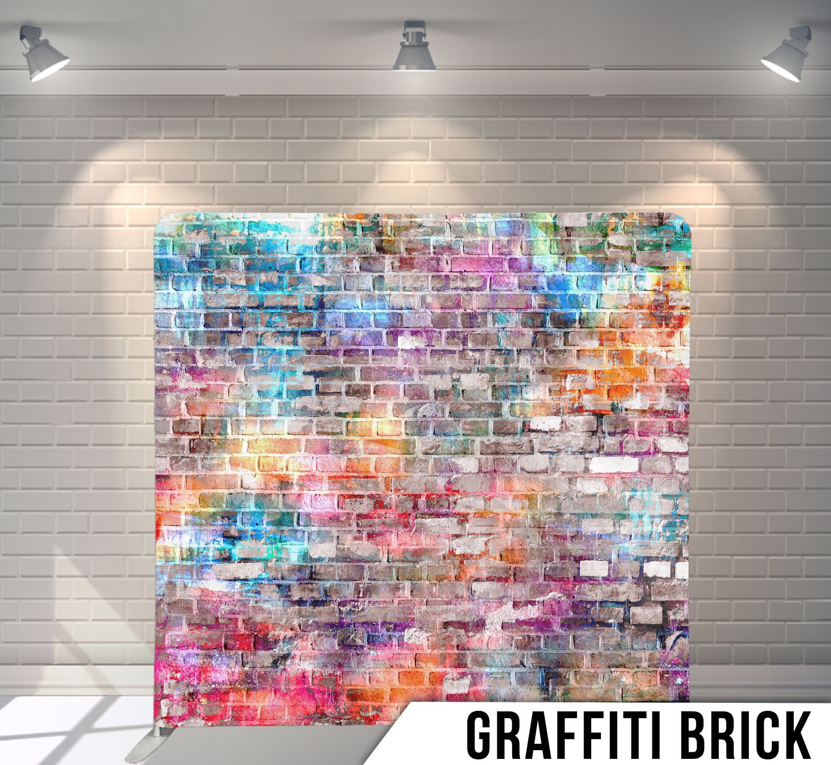 Graffiti brick wall backdrop lit by spotlights. Colorful spray paint on brick, white brick wall background.