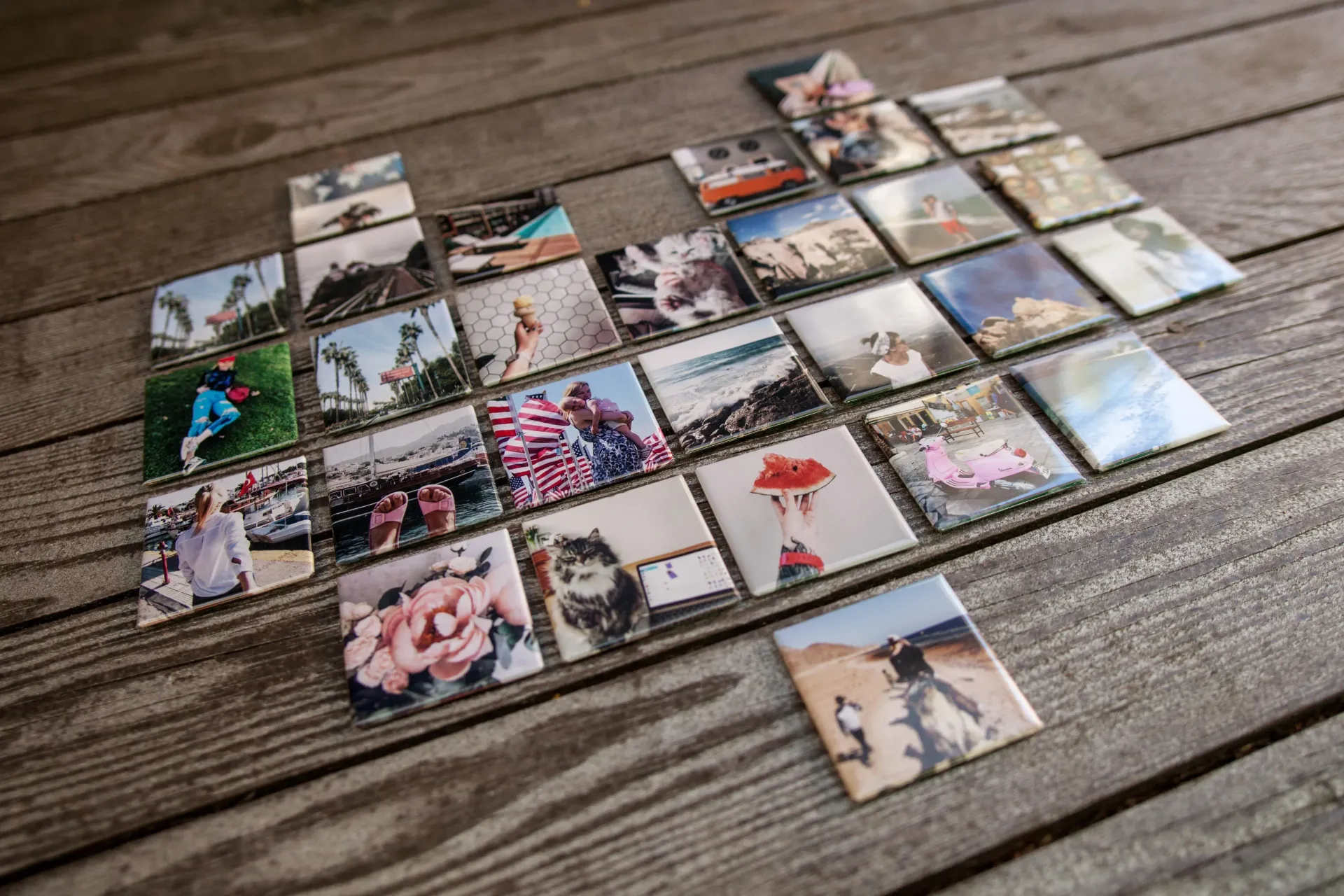 Arrangement of square photos on wooden surface; diverse images, various colors and scenes.