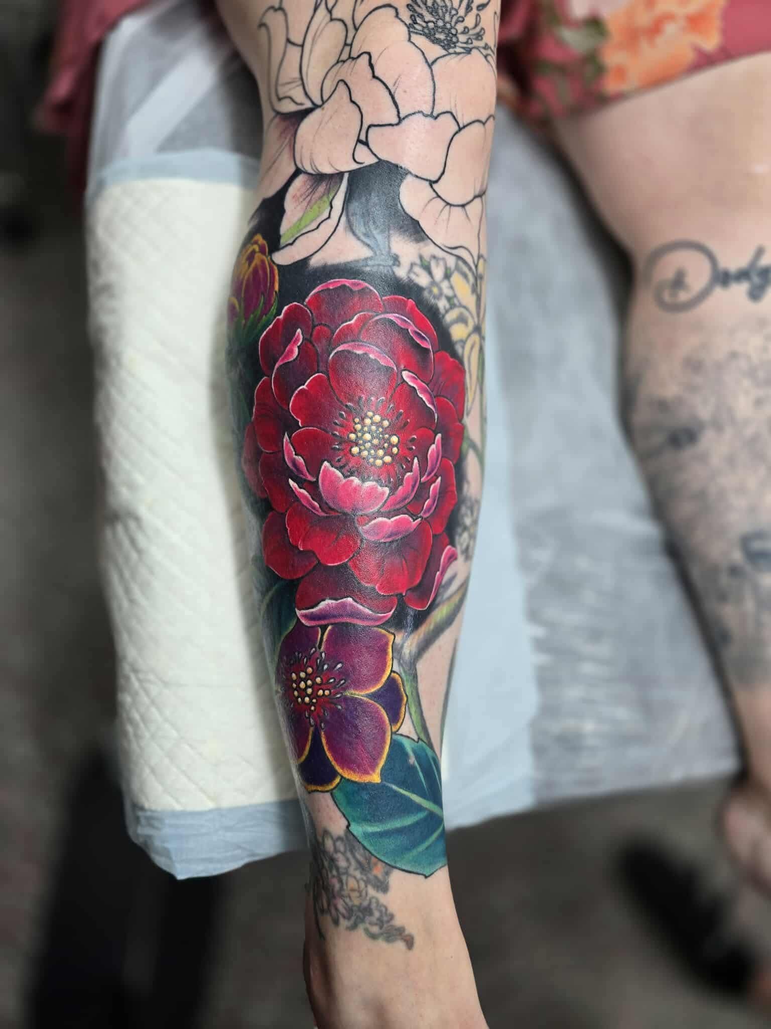 Colourful Peony Tattoo on a Leg; Red and Purple Blooms — Redback !nk Tattoo Studio in Kawana, QLD