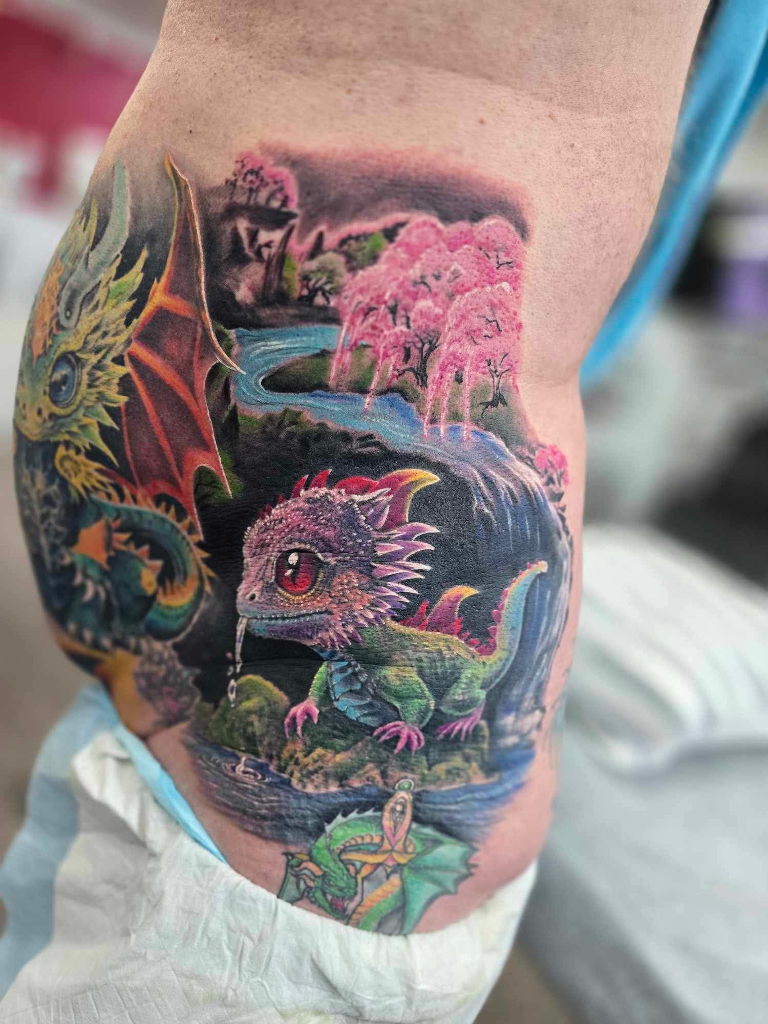 Dragon Tattoo: Baby Dragon Near a Waterfall, and a Larger Dragon — Redback !nk Tattoo Studio in Kawana, QLD