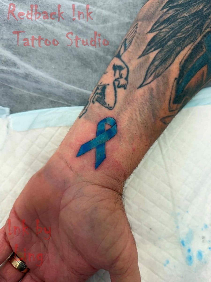 Tattooed Wrist and Forearm With a Blue Ribbon Tattoo — Redback !nk Tattoo Studio in Kawana, QLD