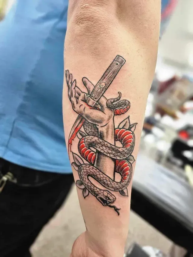 Tattoo of a Hand Holding a Straight Razor, Wrapped by a Red and Black Snake — Redback !nk Tattoo Studio in Kawana, QLD