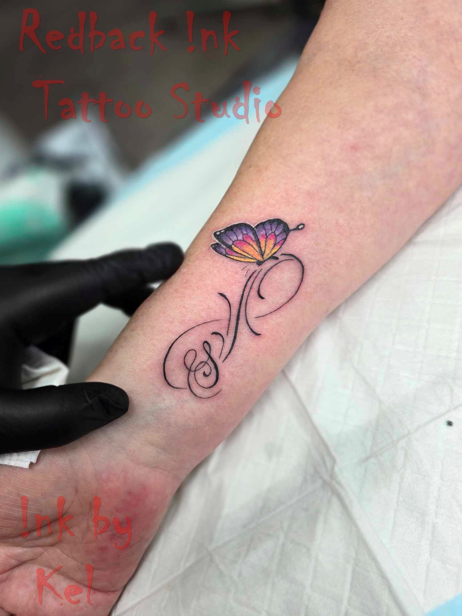 Tattoo of a Colourful Butterfly With Initials on a Wrist — Redback !nk Tattoo Studio in Kawana, QLD