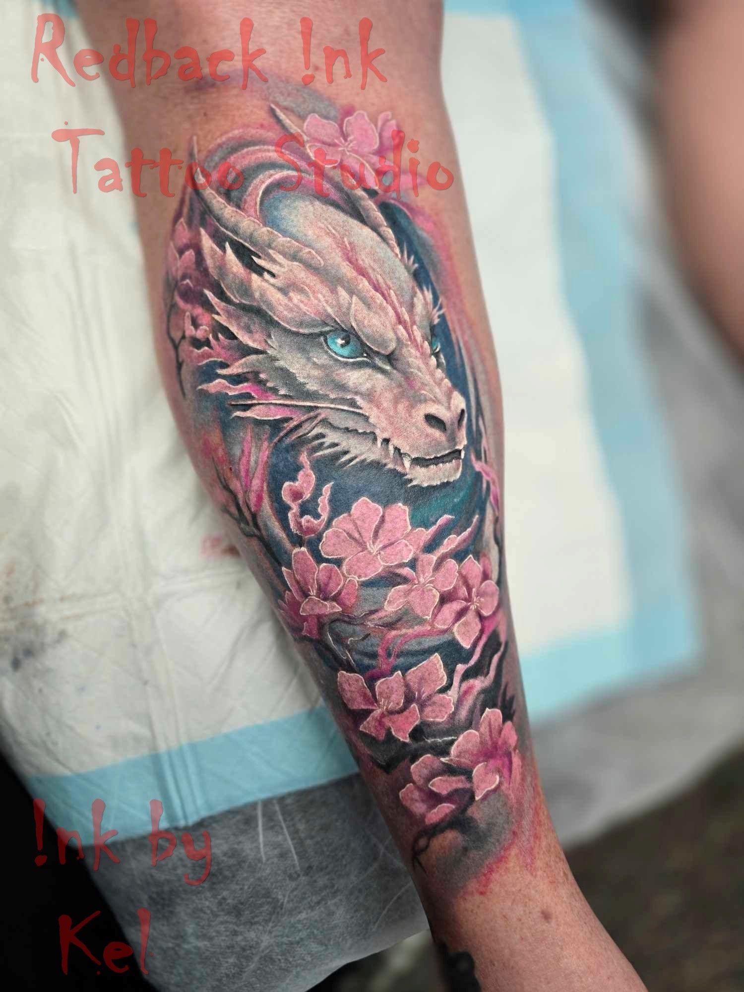 Tattoo of a White Dragon Head With Blue Eyes and Pink Cherry Blossoms — Redback !nk Tattoo Studio in Kawana, QLD