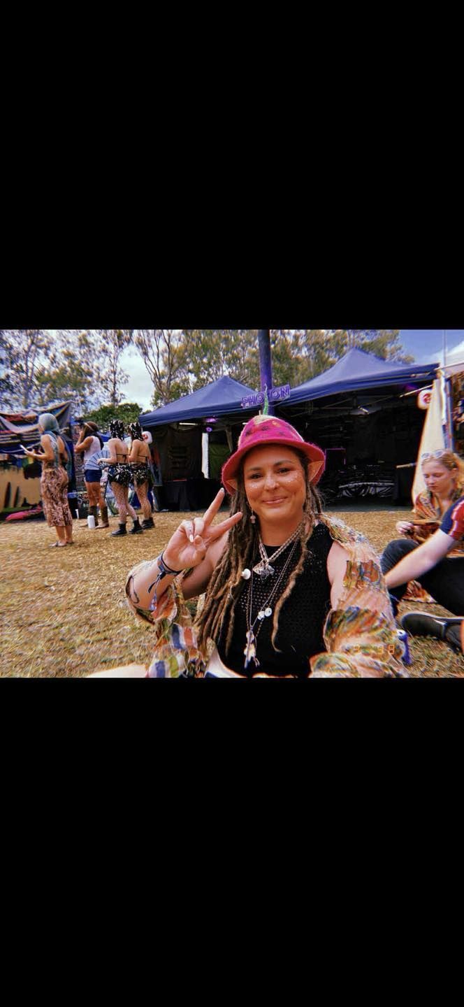 Smiling Person in a Pink Hat at an Outdoor Market — Redback !nk Tattoo Studio in Kawana, QLD