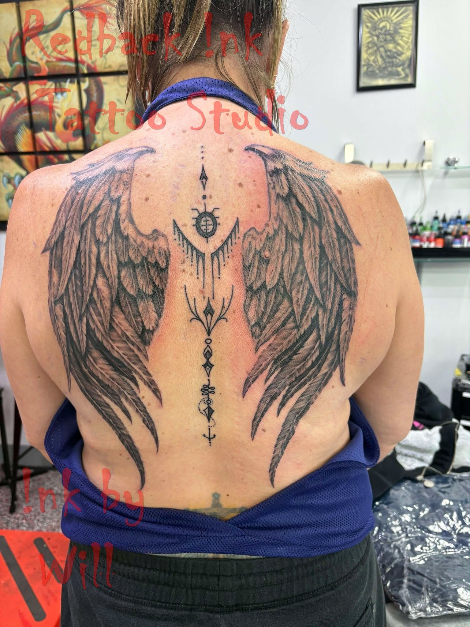 Woman's Back With Large Black Angel Wings Tattoo — Redback !nk Tattoo Studio in Kawana, QLD