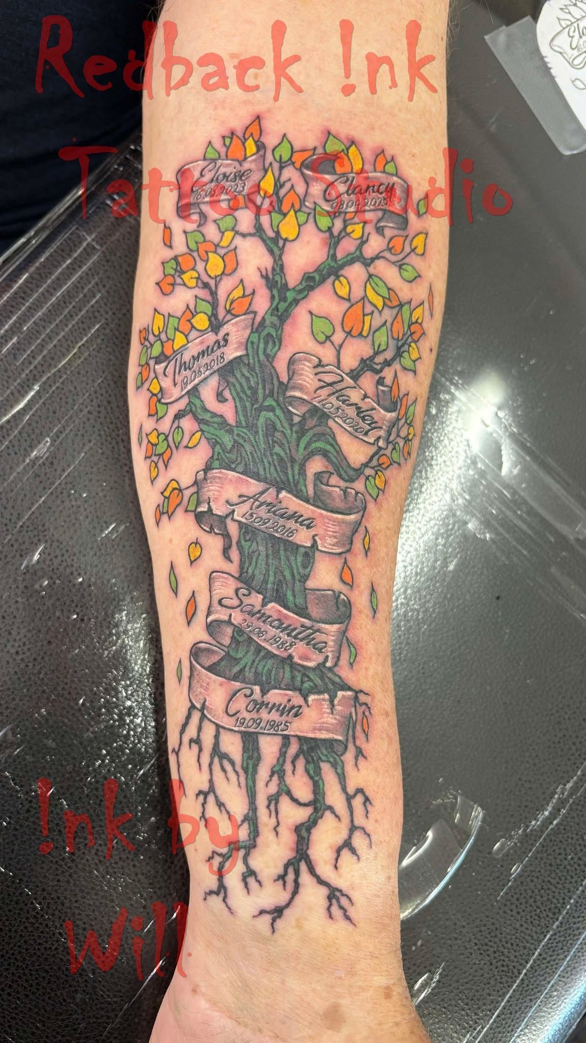 Tattoo of a Tree With Colourful Leaves, a Banner, and Roots on an Arm — Redback !nk Tattoo Studio in Kawana, QLD