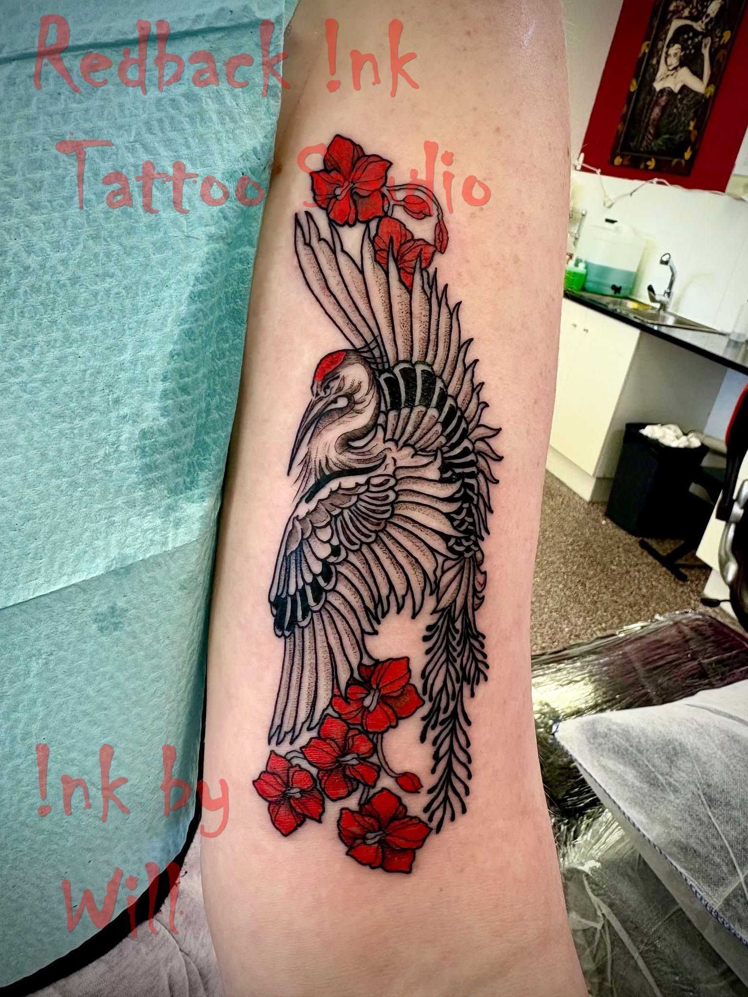 Tattoo of a Crane With Red Flowers on an Arm. Black and Red Ink — Redback !nk Tattoo Studio in Kawana, QLD