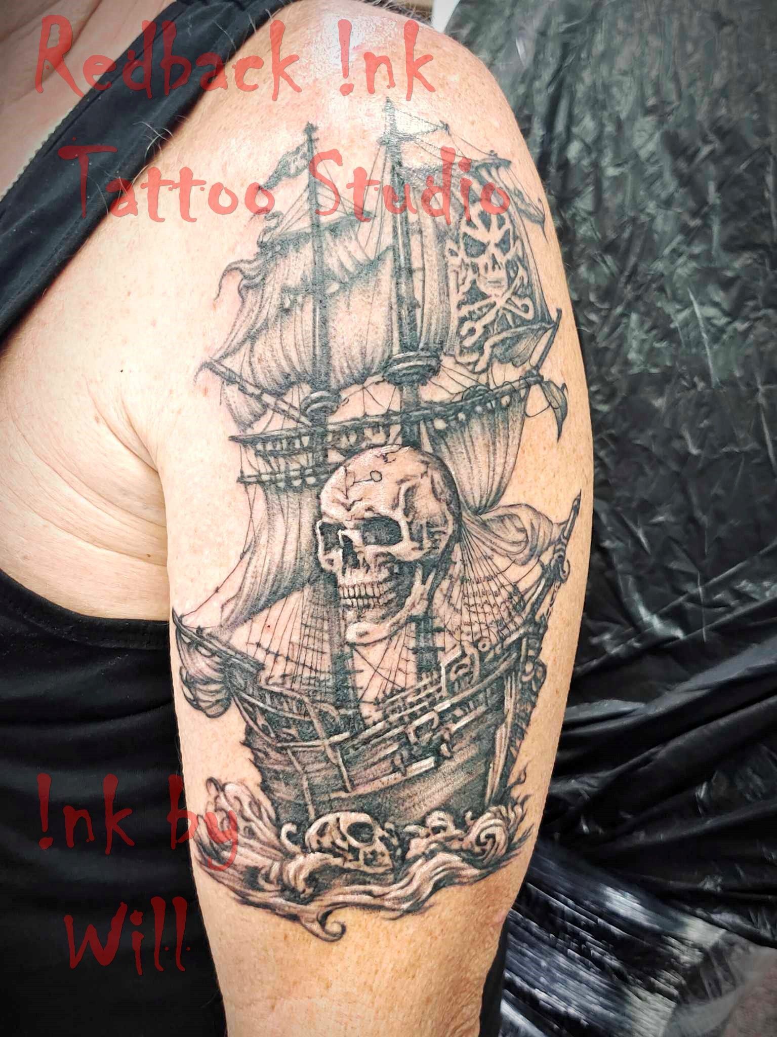 Pirate Ship Tattoo on Upper Arm Featuring Skull, Waves, and Ship Details — Redback !nk Tattoo Studio in Kawana, QLD