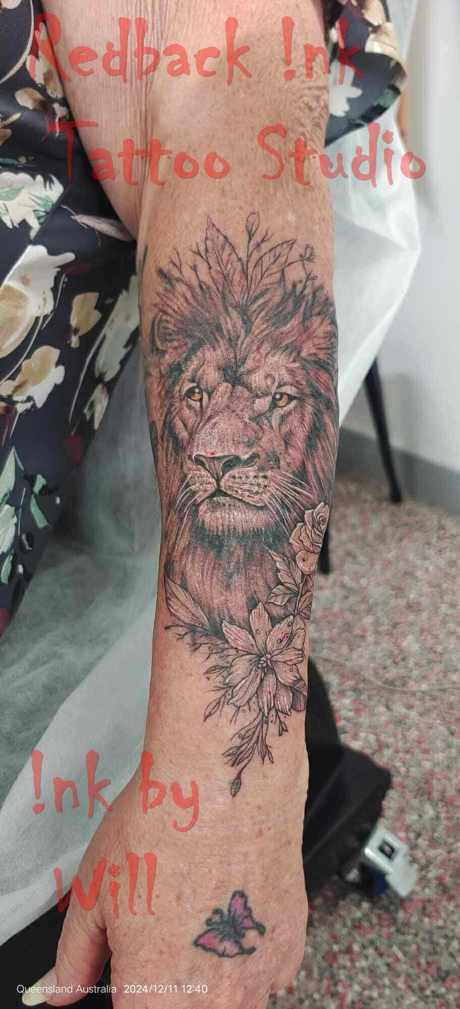Lion Tattoo on a Person's Arm, With a Butterfly Tattoo — Redback !nk Tattoo Studio in Kawana, QLD