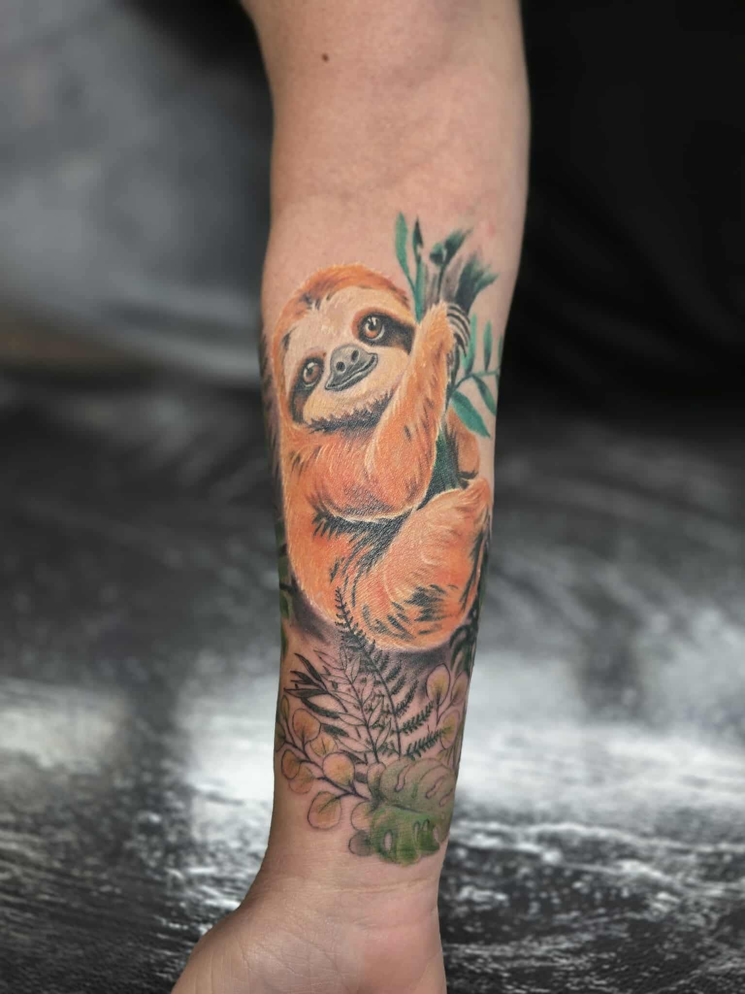 Sloth Tattoo on Arm. Orange-brown Sloth Hanging — Redback !nk Tattoo Studio in Kawana, QLD
