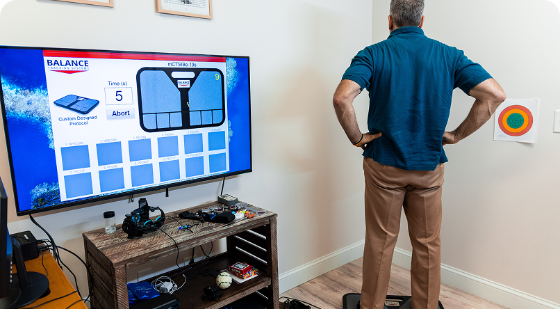 Man adjusting a security camera on a white wall with other cameras and black circles.