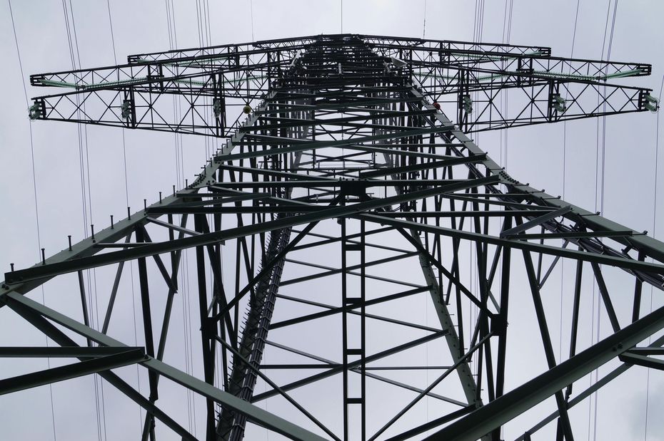 Looking up at a very tall metal structure against a cloudy sky