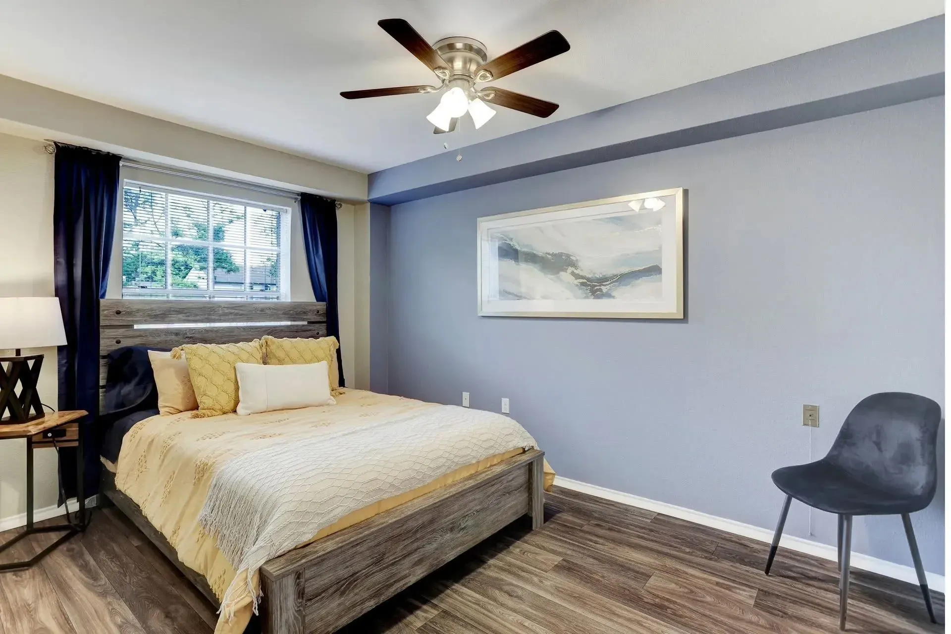 Bed with yellow and white bedding at Treemont Senior Community in Houston, Texas