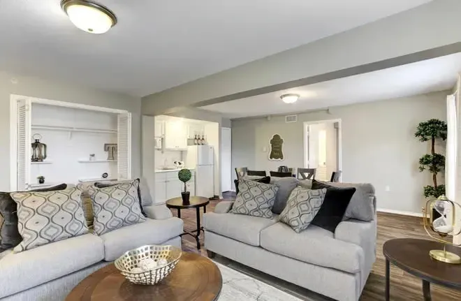 Living room with gray sofas and decorative pillows at Treemont Senior Community in Houston, Texas